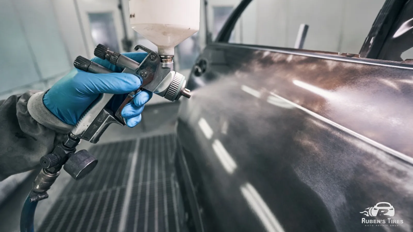 Spray painting in progress on a car door at Ruben's Tires body shop in North Semoran.