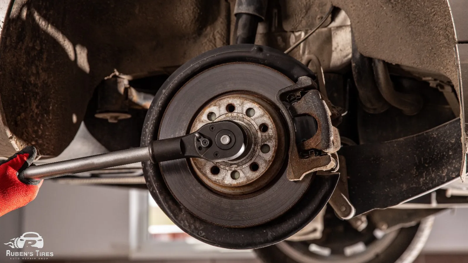 Mechanic adjusting a brake system during suspension repair at Ruben's Tires in North Semoran.